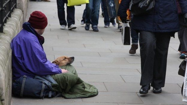 Homeless man sat on a London street with his dog. 01/04/2015. road. wealth gap. rich and poor. Begger. Homelessness.
