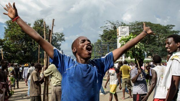 Man raises his arms in celebration in the streets of Bujumbura. 13 May 2015