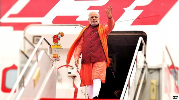 In this handout photograph taken and released by The Indian Press Information Bureau (PIB) on 14 May 2015, India's Prime Minister Narendra Modi waves on his arrival at Xian Xiangyang International Airport in Xian.