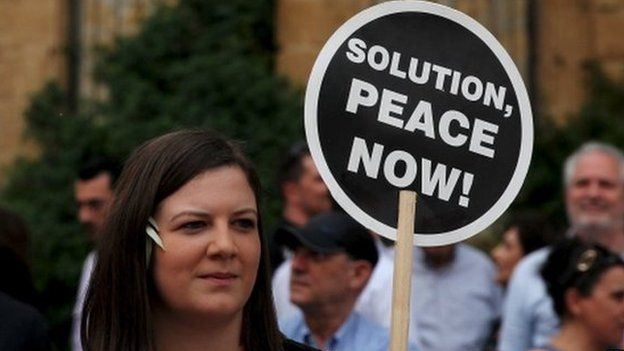 A woman holds a placard during a demonstration in favour of a peace settlement on divided Cyprus in Nicosia, 11 May 2015.