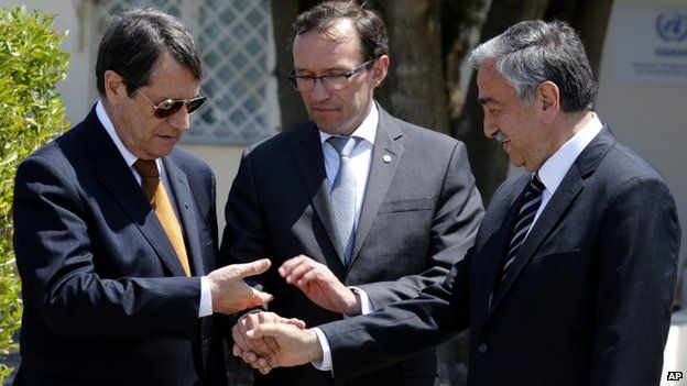 President Nicos Anastasiades, left, Turkish Cypriot leader Mustafa Akinci, right, and United Nations envoy Espen Barth Eide shake hands after their talks at a UN compound inside the UN buffer zone at the abandoned Nicosia airport, in the Cypriot divided capital Nicosia on 15 May 2015
