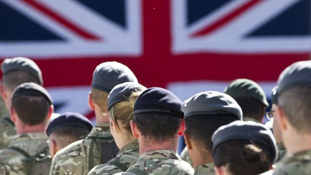 Male and female members of the armed forces gathered together for a remembrance service.