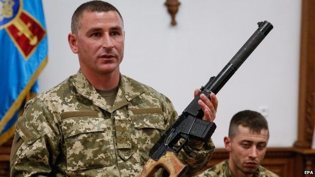 A Ukrainian soldier shows a weapon allegedly belonging to Russian servicemen captured by Ukrainian forces, during a briefing for media in General Staff of Ukrainian army in Kiev, Ukraine, 18 May 2015.