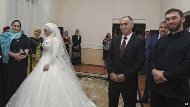 Kheda Goylabiyeva and Chechen police officer Nazhud Guchigov, second right, stand in a wedding registry office in Chechnya's provincial capital Grozny, 16 May 2015.