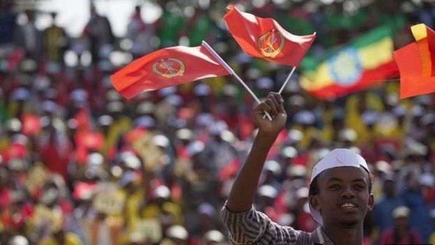 A youth waves the ruling party Ethiopian Peoples Revolutionary Democratic Front (EPRDF) flag in front of a large crowd during an election rally by the EPRDF