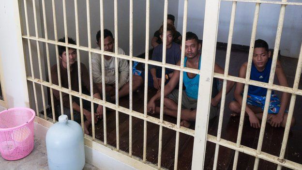 Migrant camp guards locked up in a police cell