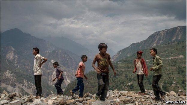 Children in the village of Marming play around on the ruins of their former school that was destroyed during the 25 April earthquake on 17 May.