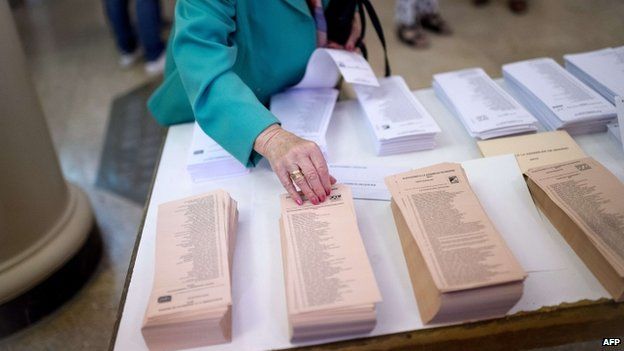 A woman chooses her ballots in Spain"s municipal and regional elections at a polling station in Madrid on May 24, 2015