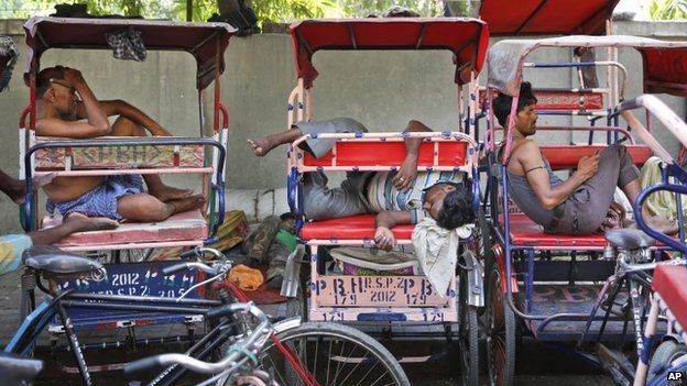 Indian rickshaw pullers sleep in their rickshaws on a hot summer day in New Delhi, India, Thursday, May 21, 2015.