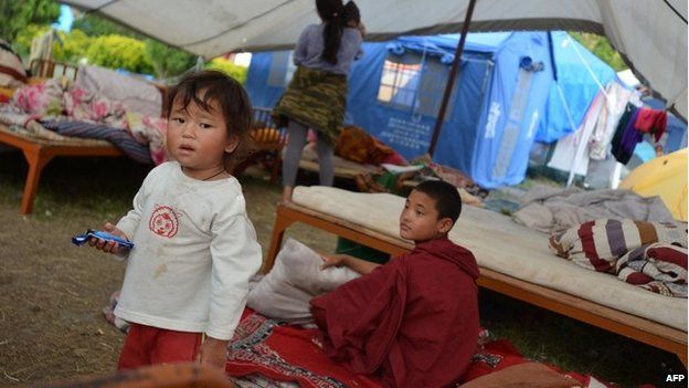 Children sit inside a makeshift tent for earthquake victims in Kathmandu