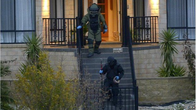 Police officers wearing bomb suits raid a home in Greenvale, Melbourne, Australia