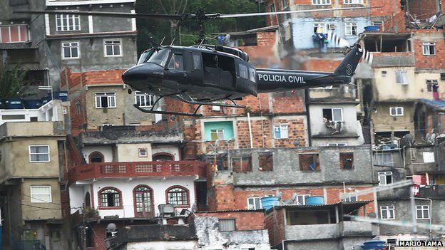 A police helicopter flies in front of a favela in Rio