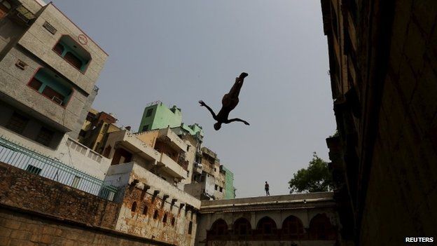 A boy jumps into a step well built inside the shrine of Sufi Saint Nizamuddin Auliya in New Delhi, India May 24, 2015.