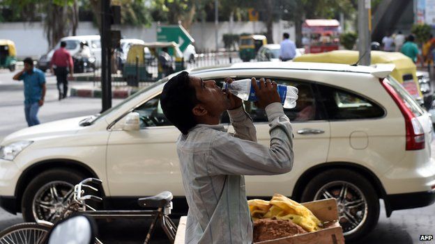 An Indian labourer takes a break as he drinks water to get respite from heat in New Delhi on May 26, 2015