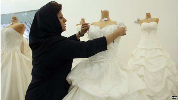 Woman adjusts a wedding dress in a shop in tehran (file photo)