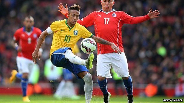 Neymar of Brazil controls the ball under pressure from Gary Medel of Chile