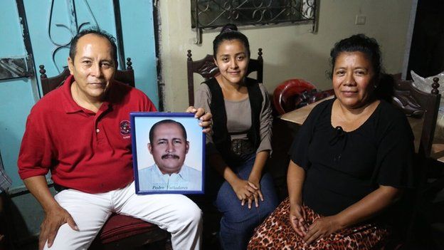The family of Pedro Valladares Martinez hold up his photograph