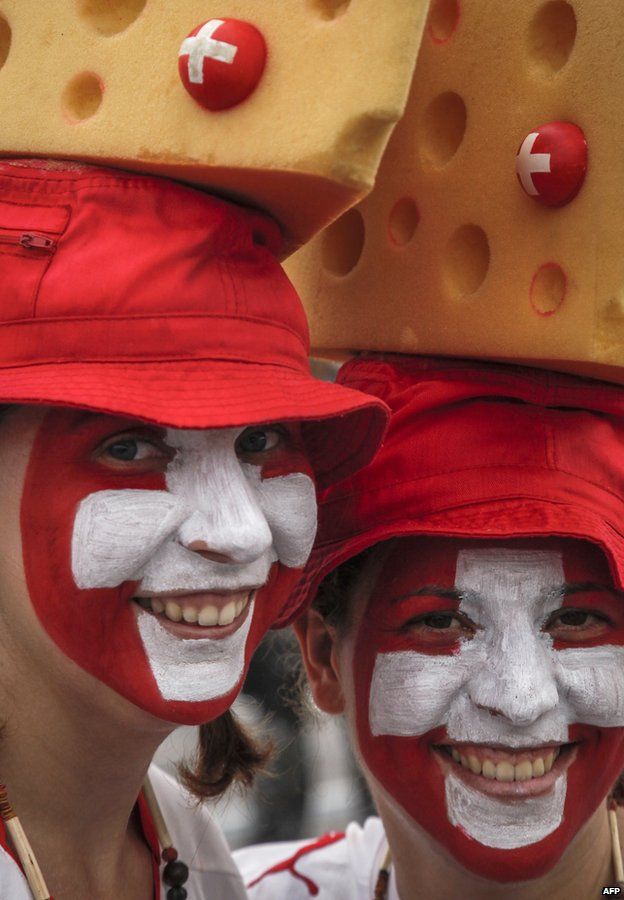Switzerland's fans wear Swiss cheese hats before entering the Amazonia Arena in Manaus, Brazil, before the start of the FIFA World Cup Group E football match between Honduras and Switzerland on June 25, 201