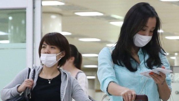 Two Japanese tourists wearing facial masks arrive at Gimpo airport, western Seoul, South Korea, 29 May 2015, as South Korea confirmed two additional cases of the Middle East Respiratory Syndrome (MERS), raising the number of patients diagnosed with the virus to nine.