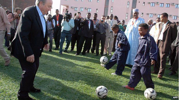 FIFA President Sepp Blatter kicks around a soccer ball with Sudanese youth at the inauguration of a FIFA-sponsored football turf playing field, in Khartoum, 11 February 2007