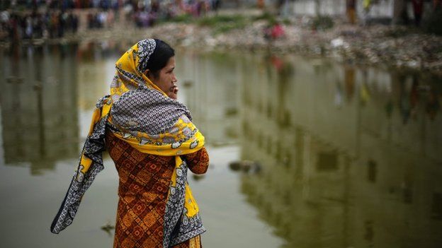 A fellow garment worker stands at the site of the Rana Plaza building to mark the second anniversary of the buildings collapse, at Savar, in Dhaka, Bangladesh, 24 April 2015.