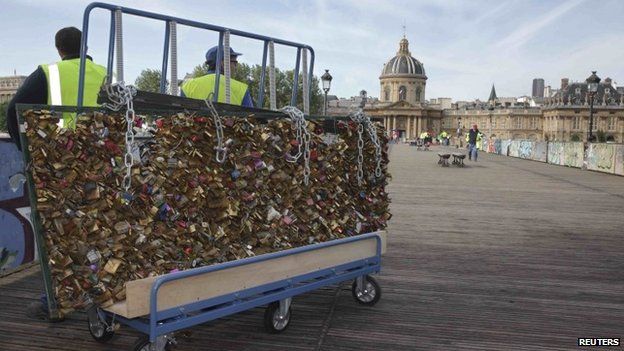 City municipal employees remove iron grills covered with "lovelocks" on the Pont des Arts which crosses over the River Seine in Paris, France, June 1, 2015