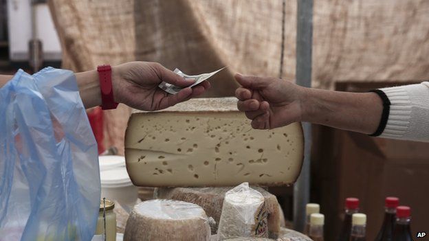 Consumer buys cheese at Athens market (30 May)