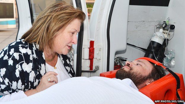 Casey Coombs lying on a stretcher upon his arrival in Oman