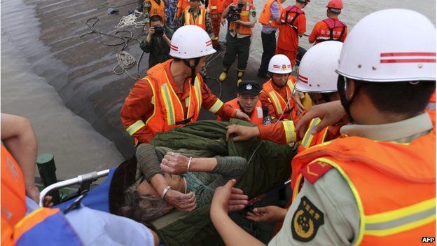 An elderly survivor (C) is carried onto the river bank after being rescued from the Dongfangzhixing or "Eastern Star" vessel which sank in the Yangtze river in Jianli, central China"s Hubei province on 2 June 2015.