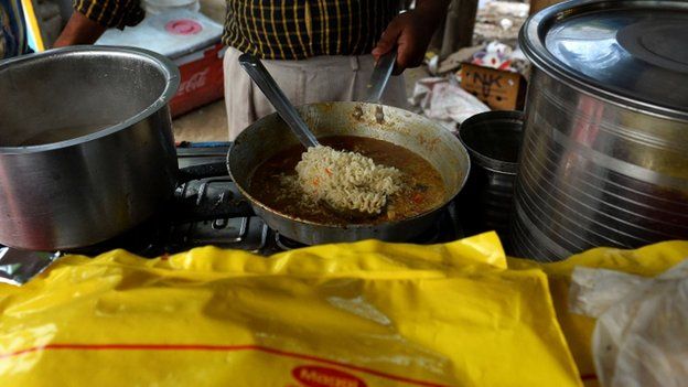 An Indian youth prepares Nestle "Maggi" instant noodles at his makeshift roadside food stall on the outskirts of New Delhi on June 3, 2015.