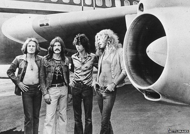 British rock band Led Zeppelin, (left - right): John Paul Jones, John Bonham (1948 - 1980), Jimmy Page and Robert Plant, pose in front of an airplane, 1970s.