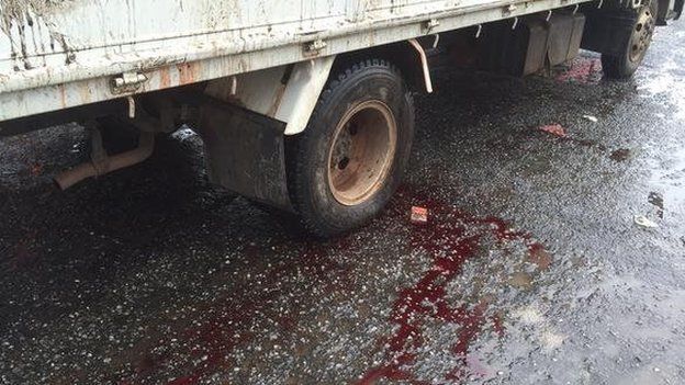 Blood on the road under a truck