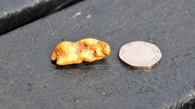 Gold nugget next to 20p