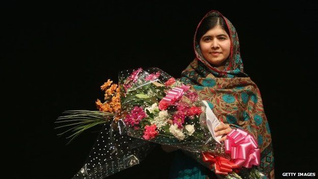 Malala Yousafzai holds a bouquet of flowers, given to her on behalf of the Pakistani Prime Minster
