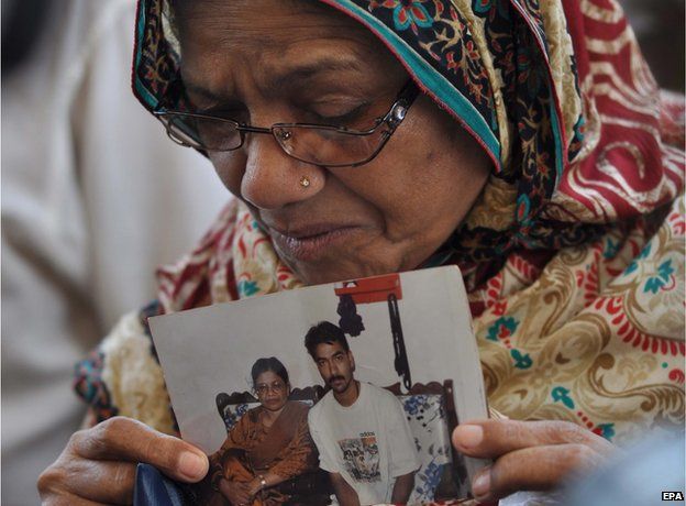 The mother of convicted activist Saulat Mirza, holds a portrait of her son after his body arrived for burial in Karachi on 12 May 2015