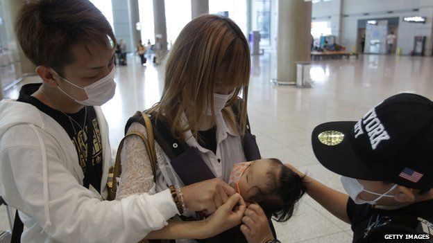 Tourists wear masks as a precaution against the Mers virus at the Incheon International Airport on 6 June