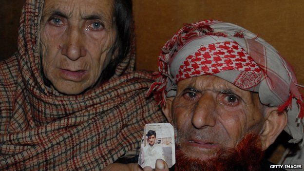 Kashmir parents of convicted killer Shafqat Hussain, displaying a photograph of their son, in Muzaffarabad,