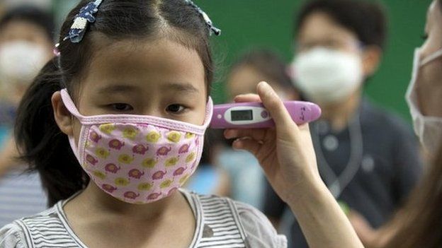 A pupil receives a temperature check at an elementary school in Seoul - 8 June 2015