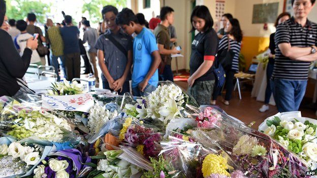 Malaysians look at flowers laid our for victims of an earthquake last week
