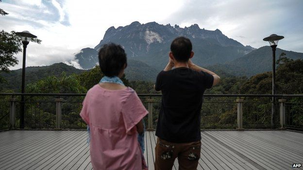 Tourists take pictures of Malaysia's Mount Kinabalu