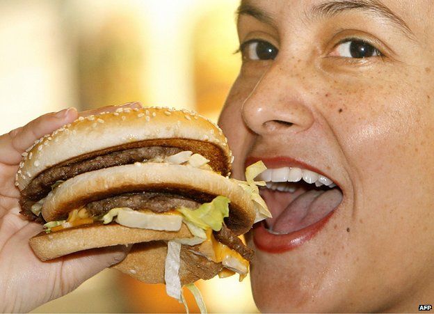 Girl eating hamburger at McDonald's in Munich - file pic