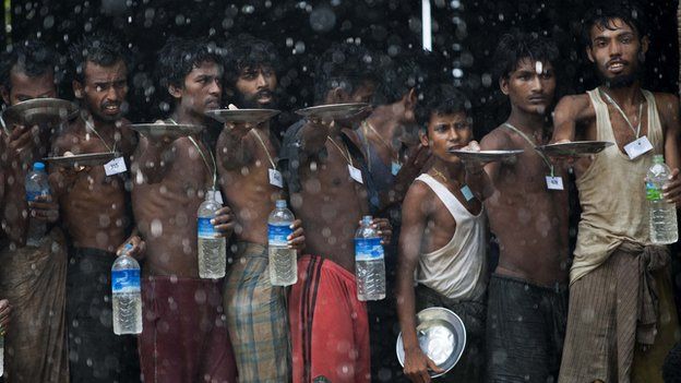 Rohingya migrants collect rain water at a temporary shelter in Myanmar's northern Rakhine state