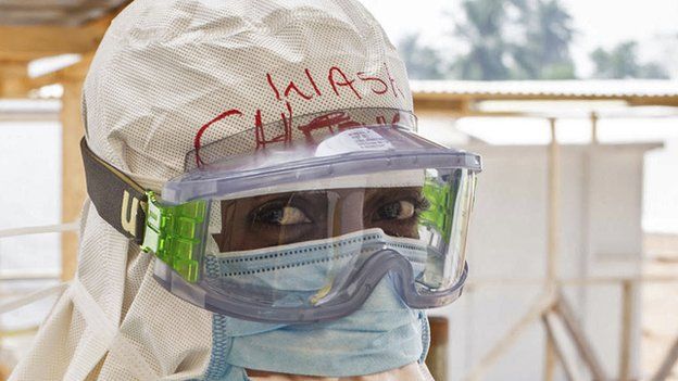 A health care worker wearing virus protective gear before entering a high risk zone at an Ebola virus clinic operated by the International Medical Corps in Makeni, Sierra Leone 2 March 2015