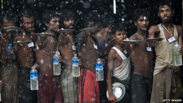 Rohingya migrants collect rain water at a temporary shelter in Myanmar's Rakhine state