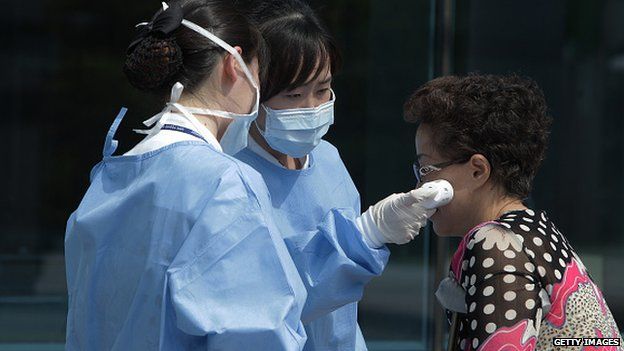 Medical staffs check the temperature of a visitor at Seoul Medical Center