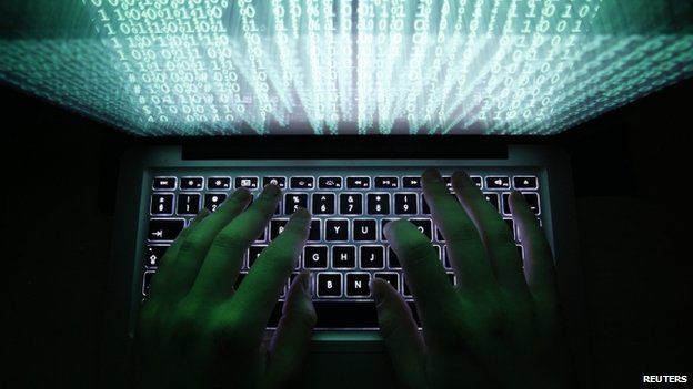 A man types on a computer keyboard