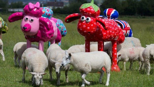 Shaun the Sheep sculptures in a field with real sheep