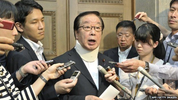 Hiromichi Watanabe (C), chairman of Lower House"s Labor committee, is surrounded by reporters as he wears a corset on his neck after a tussle with opposition lawmakers at the National Diet in Tokyo on June 12, 2015.