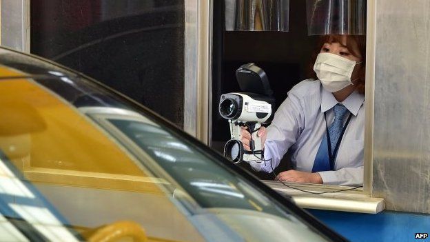 South Korean border worker checks driver's body heat