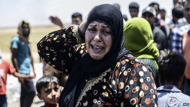 A Syrian woman cries after a US-led coalition air strike on IS militants in Tal Abyad (14 June 2015)